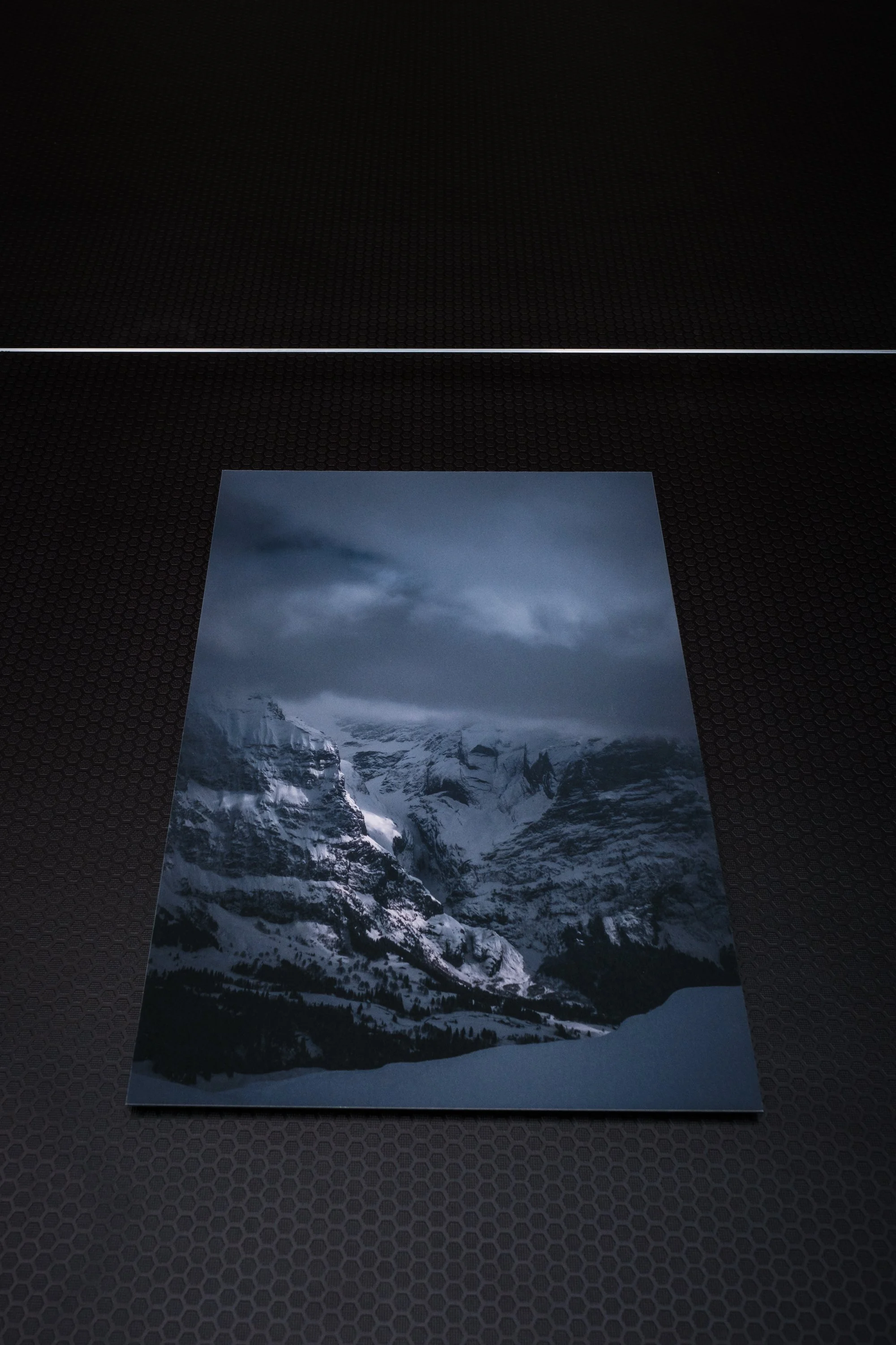 Fotografie von verschneiten Bergen und Wolken am Himmel im winterlichen Landschaftsmotiv.